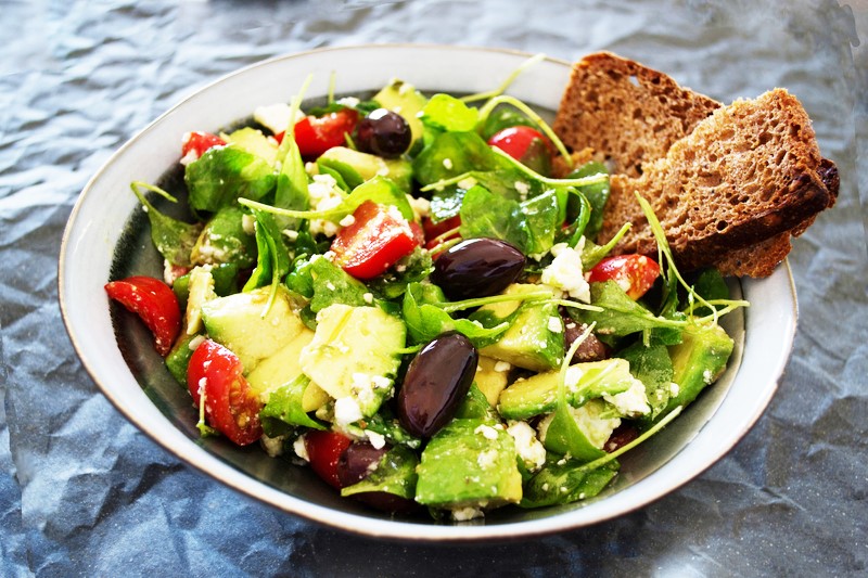 a plate with avocado and rocket arugula salad